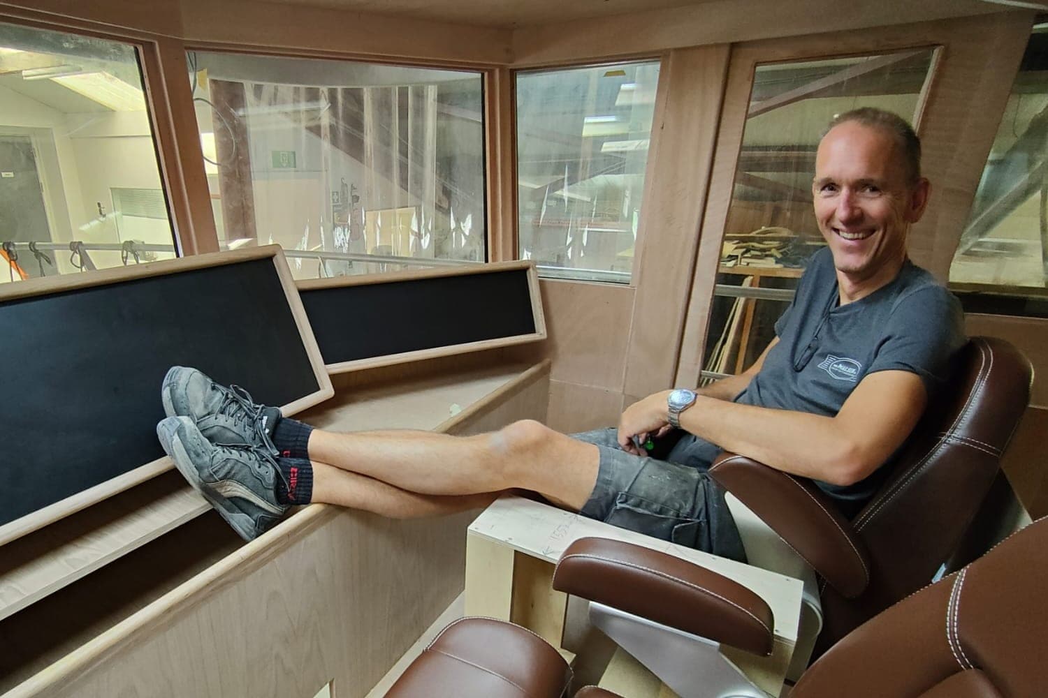 Roland van Malsen in een stuurhut in aanbouw, in de werkplaats in Makkum